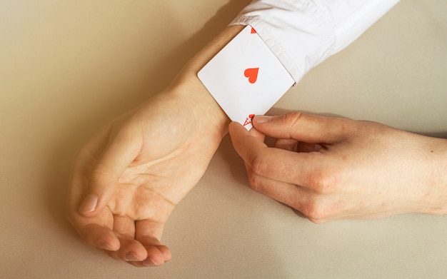 Close up of a man's hand removing ace from sleeves