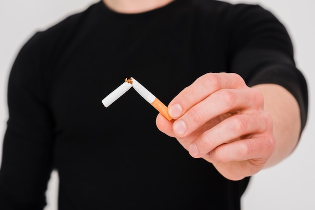 Close-up man's hand showing broken cigarette