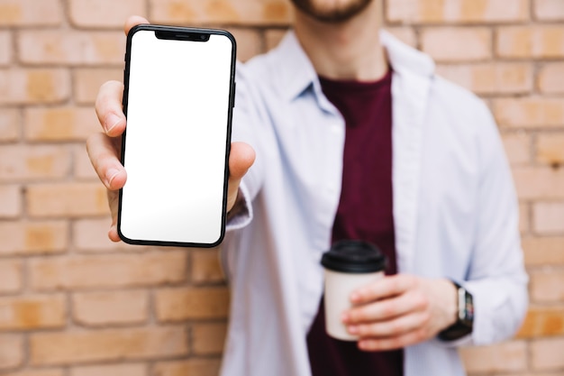 Close-up of man's hand showing smartphone with blank white screen