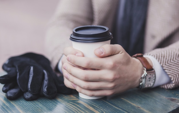 コーヒーを飲みながら人間の手のクローズアップ