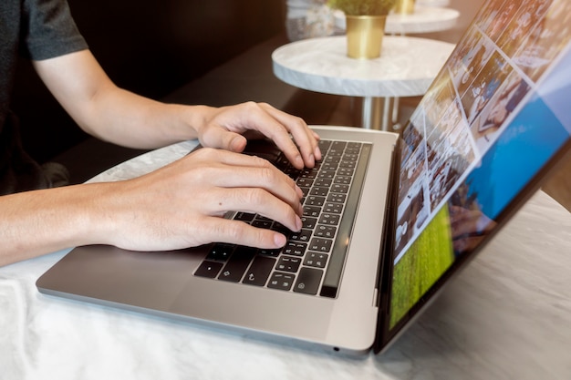 Close up man's hand  working on Laptop in coffee shop 