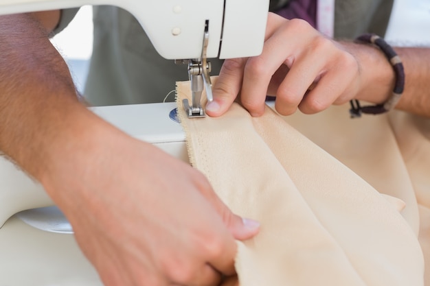 Close up of man sewing 