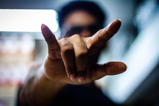 Photo close-up of man showing horn sign