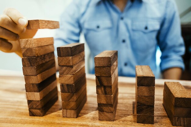 Foto close-up di un uomo che impila blocchi di giocattoli di legno