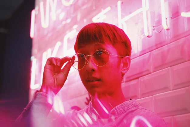 Photo close-up of man in sunglasses by illuminated store