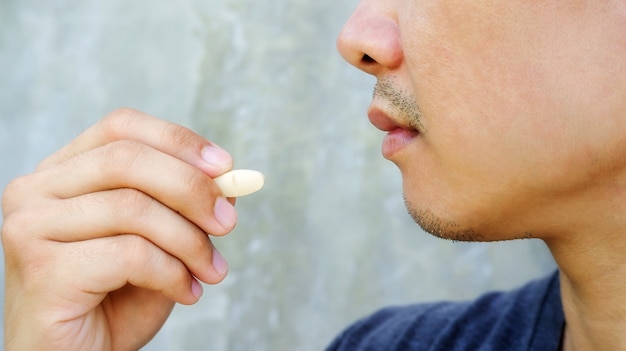Close up of a man take a pill