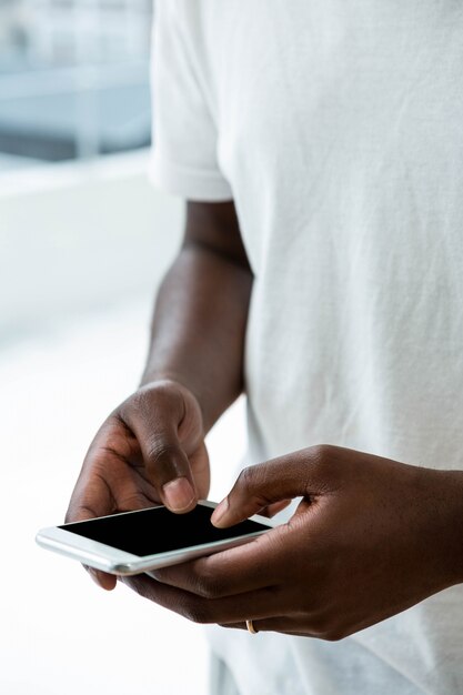 Close-up of man text messaging on mobile phone at home