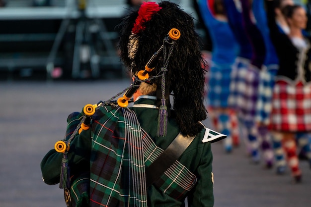 Photo close up of a man in traditional scottish attire is playing the traditional scottish bagpipes