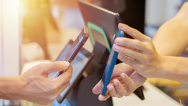 Photo close up man uses mobile phone to scan qr code for payment