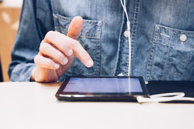 テーブルでデジタルタブレットを使用している男性のクローズアップ