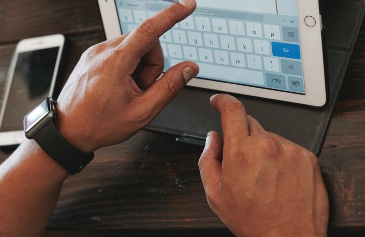Photo close-up of man using digital tablet on table