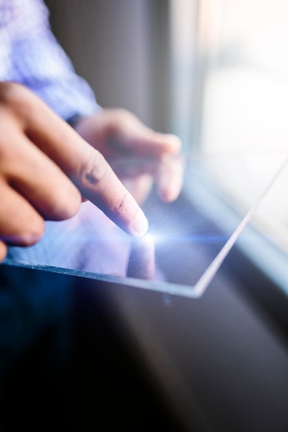 Foto primo piano dell'uomo che utilizza un tablet futuristico