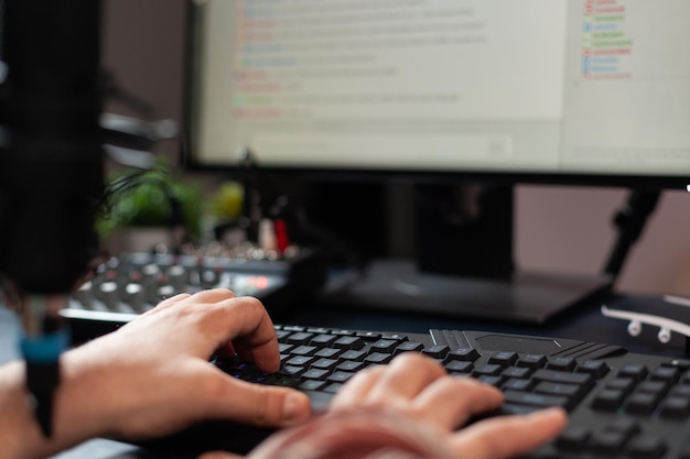 Close up of man using keyboard on live stream chat. Person streaming online on computer, using control keys to talk to audience. Streamer broadcasting gameplay with modern equipment