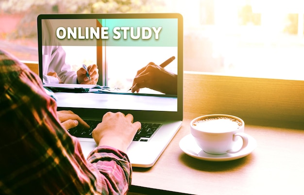 Photo close-up of man using laptop by coffee on table