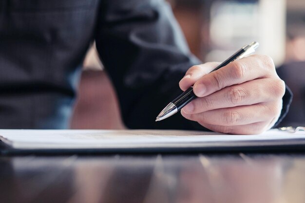 Close-up of man using mobile phone on table