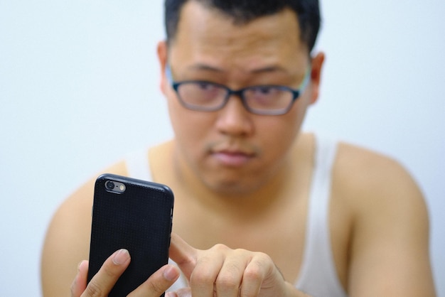 Close-up of man using phone against white background