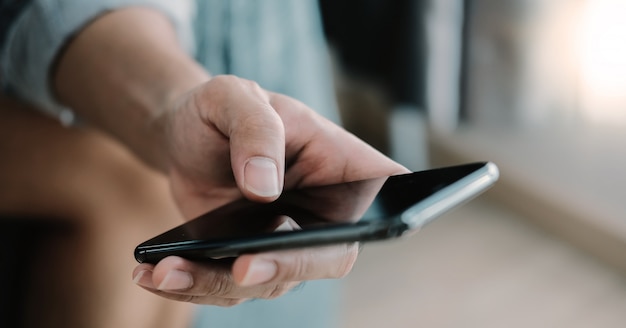 Close up man using smart phone at home