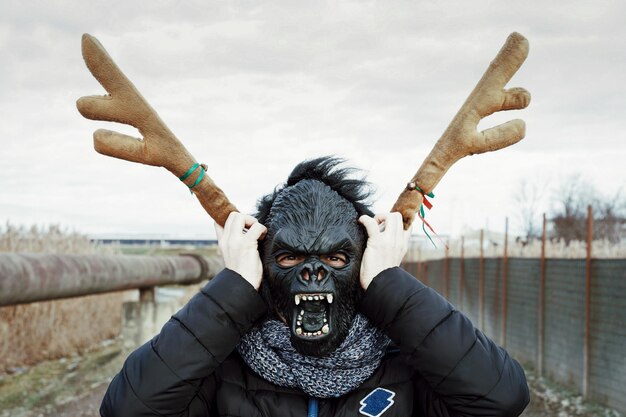 Photo close-up of man wearing gorilla mask against sky