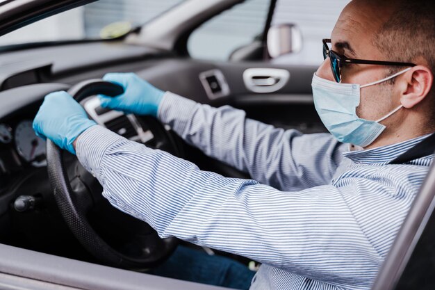 マスクをかぶった男性が車に座っているクローズアップ