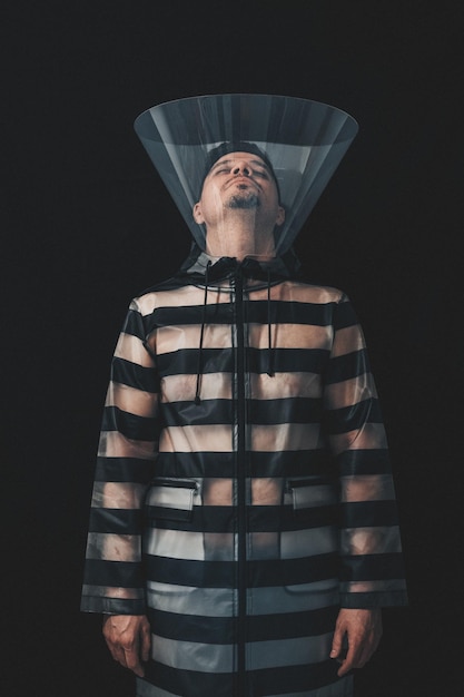 close-up of man wearing protective collar against black background