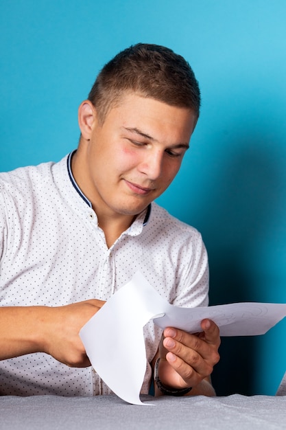 Close-up of a man in a white shirt holds scissors