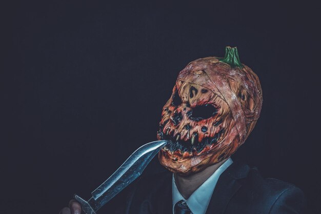 Close-up di un uomo con il trucco di halloween su uno sfondo nero