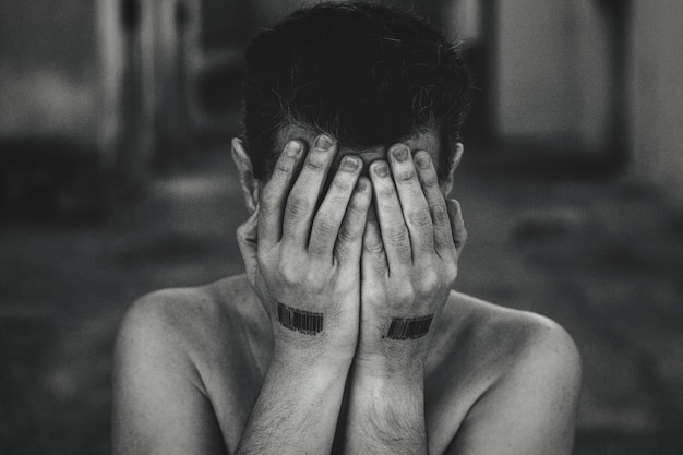 Photo close-up of man with hands covering face