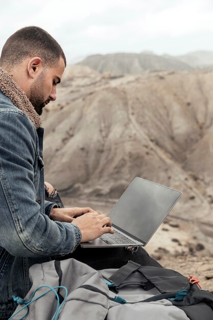 Крупным планом человек с ноутбуком на открытом воздухе