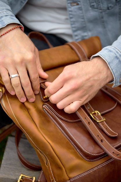 close up man with leather brown backpack travel, people lifestyle, having handmade accessories. focus on backpack, copy space