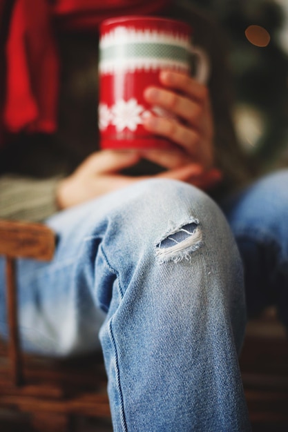 Photo close-up of man with mug sitting on chair