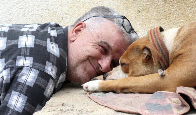 Foto close-up di un uomo con un cane addormentato