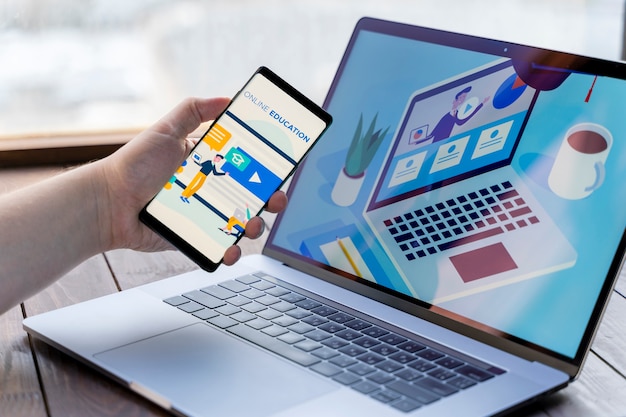 Photo close-up man with smartphone and laptop indoors