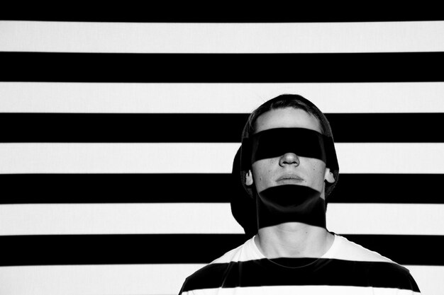 Photo close-up of man with striped shadow against wall