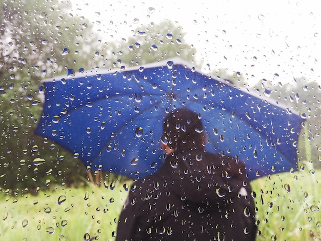 Photo close-up of man with umbrella during rain