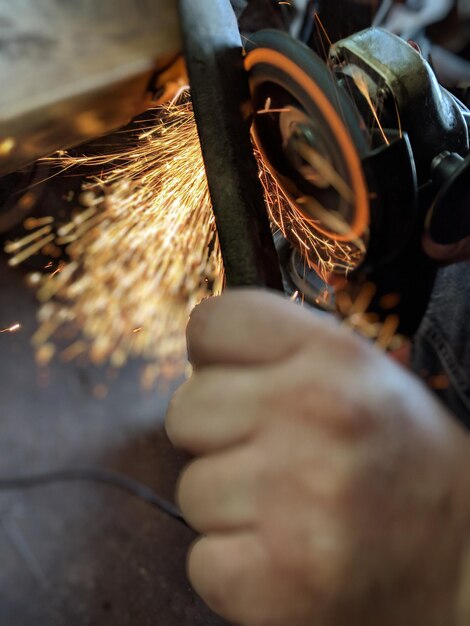 Photo close-up of man working on metal in factory