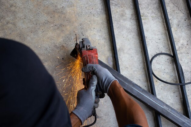 Close up, A man working with angle grinder. Iron gate repair