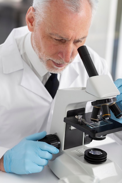 Photo close up man working with microscope