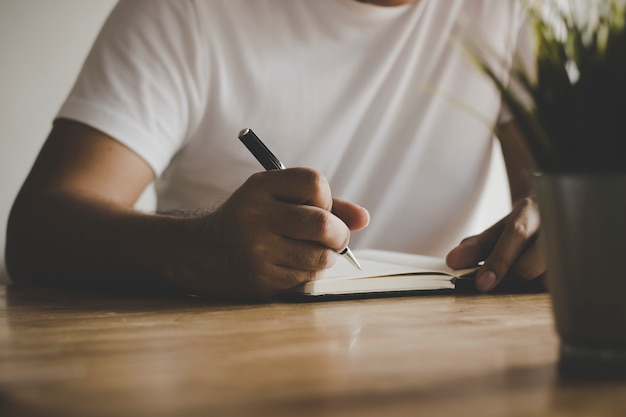 Photo close up man writing memory on table in vintage style