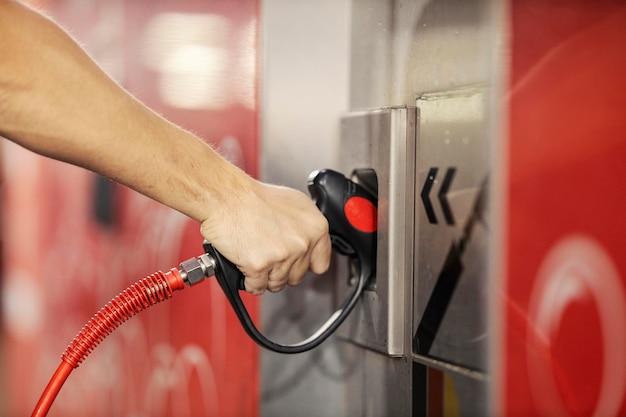 Photo close up of man39s hand taking high pressure water gun at carwash station