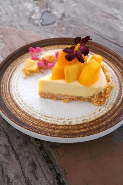 Foto close up mango cheesecake op een houten tafel