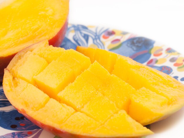 Close-up of mango in plate on white background