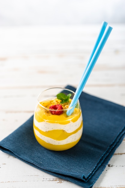 Крупным планом манго пюре с йогуртом на белом столе