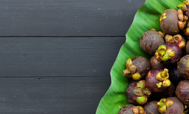 Close up of mangosteen fruit on black wood table