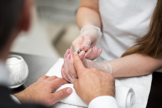 Primo piano di una manicure che taglia la cuticola dalle dita della persona