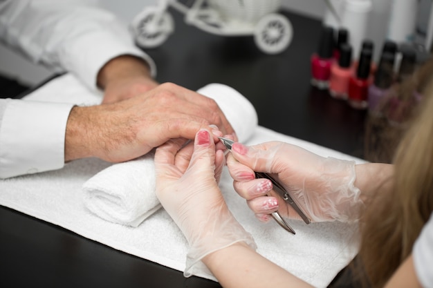 Close-up Of A Manicurist Cutting Off The Cuticle From The Person's Fingers