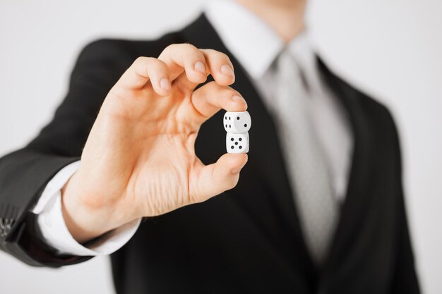 close up of mans hand holding white casino dice