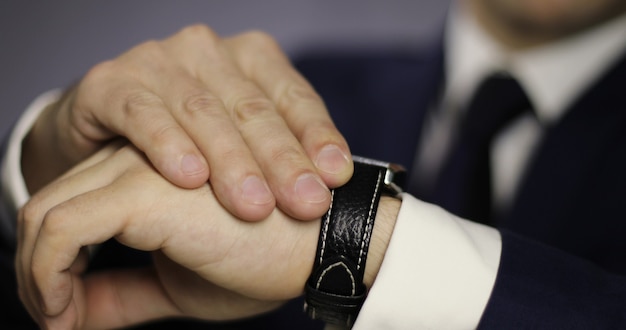 Close-up mans hand met een klok Jonge mannelijke zakenman wacht op een meeting