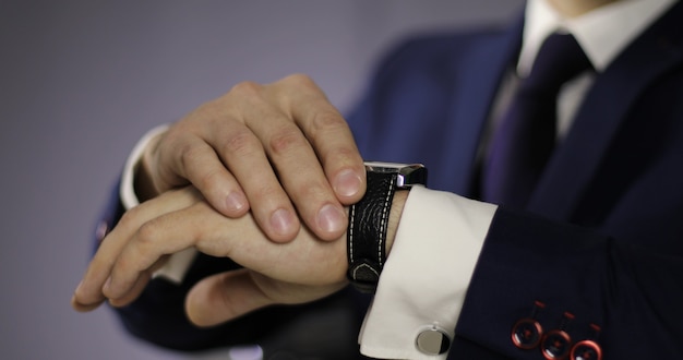 Close up mans hand with a clock Young male business man is waiting for a meeting