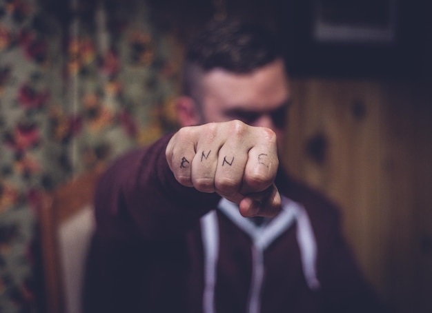 Foto close-up delle dita tatuate dell'uomo