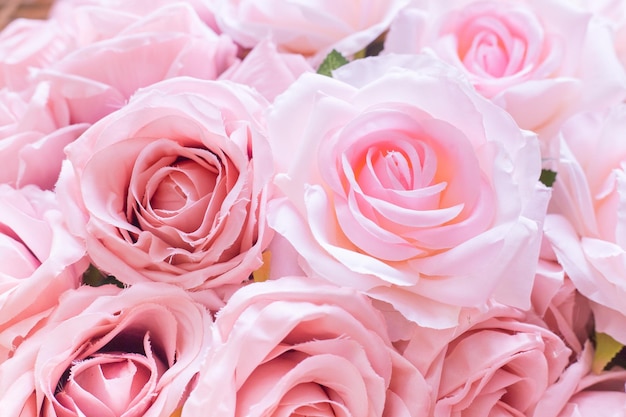Primo piano di molte rose rosa pallido in tessuto con sfondo sfocato